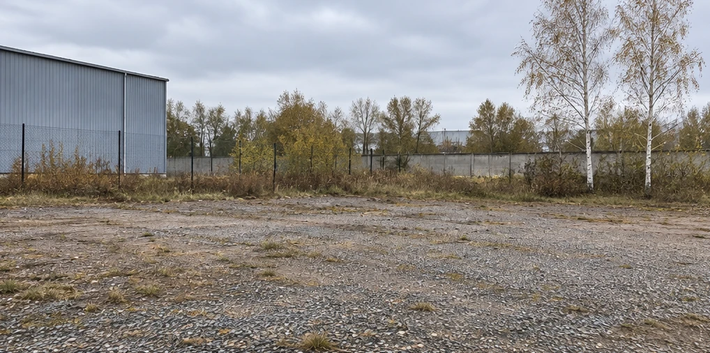 Панельный бетонный забор на опорах. Участок до установки ограждения. Ограждение гравийной площадки у склада. Визуализация.
